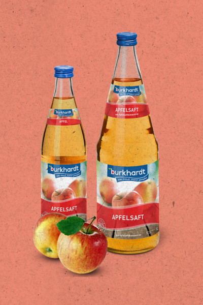 Produktpräsentation von Burkhardt Fruchtsäfte: Zwei Glasflaschen (1,0l und 0,5l) klarer Apfelsaft mit blauen Verschlüssen und zwei frischen Äpfeln im Vordergrund auf korallfarbenem Grund.