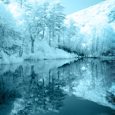 Das Bild zeicht einen Fluss und eine Berglandschaft drum herum die durch eine Wärmekammera Weiß und Blau aussehen