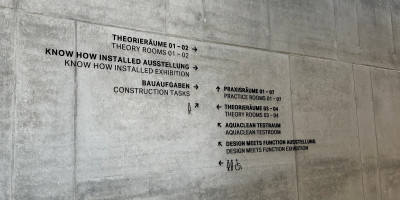 Detailliertes zweisprachiges Wegeleitsystem als Signaletik im Geberit Campus Pfullendorf mit Wegweisern zu Theorieräumen, Ausstellungen und Praxisräumen