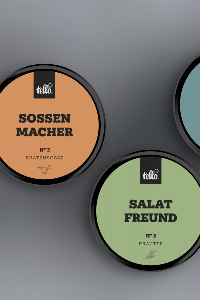 Grafische Draufsicht auf zwei tellofix Gewürzdosen auf grauem Grund: Eine orangefarbene Dose ‚Sossen Macher No. 3 Bratensosse‘ und eine hellgrüne Dose ‚Salat Freund No. 2 Kräuter‘